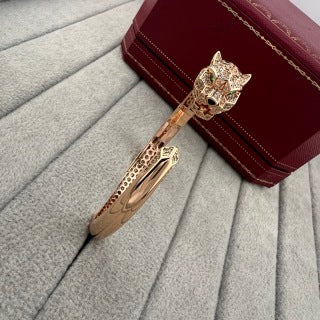 Cartier open-style cuff bracelet featuring a diamond-set panther head and spotted motif.