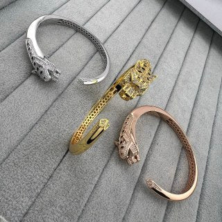 Cartier open-style cuff bracelet featuring a diamond-set panther head and spotted motif.